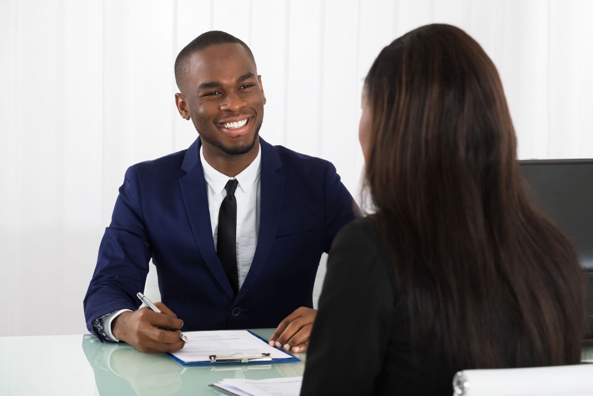 Male Human Resources Manager Interviewing A Young Female Applicant In Office