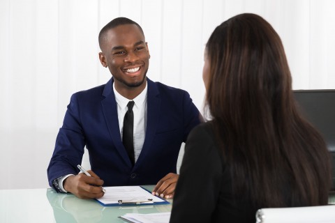 Male Human Resources Manager Interviewing A Young Female Applicant In Office